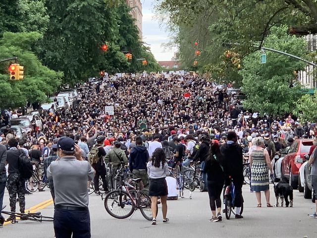 Hundreds of people are on 86th Street by Gracie Mansion